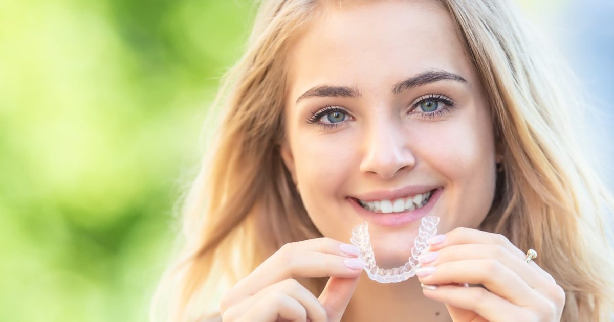 Teen holding a clear Invisalign aligner in Waterdown